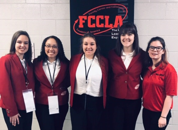 Five girls posing for picture with FCCLA banner behind them